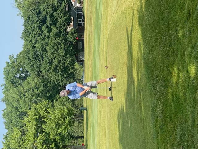 A golfer preparing to drive from the tee
