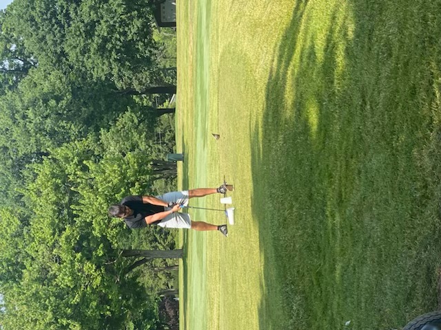 Another golfer preparing to drive from the tee