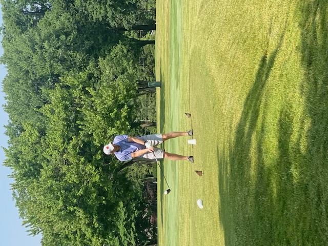 A golfer preparing to drive from the tee